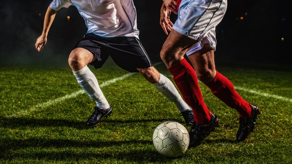 Action shot of people playing soccer.