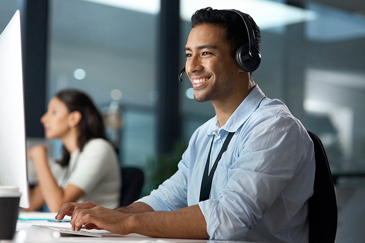 Man working on computer while talking on headset