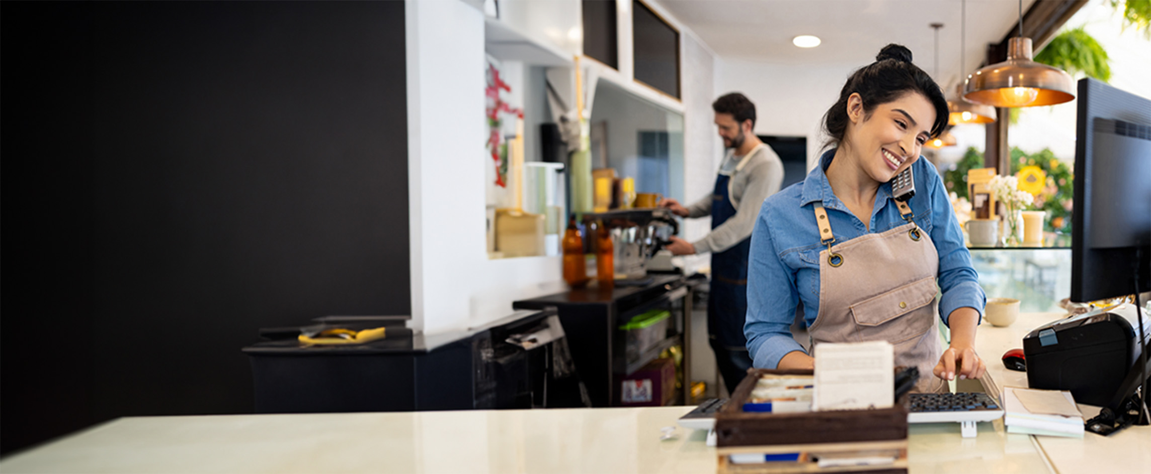 Happy small business owner multi-tasks at work.