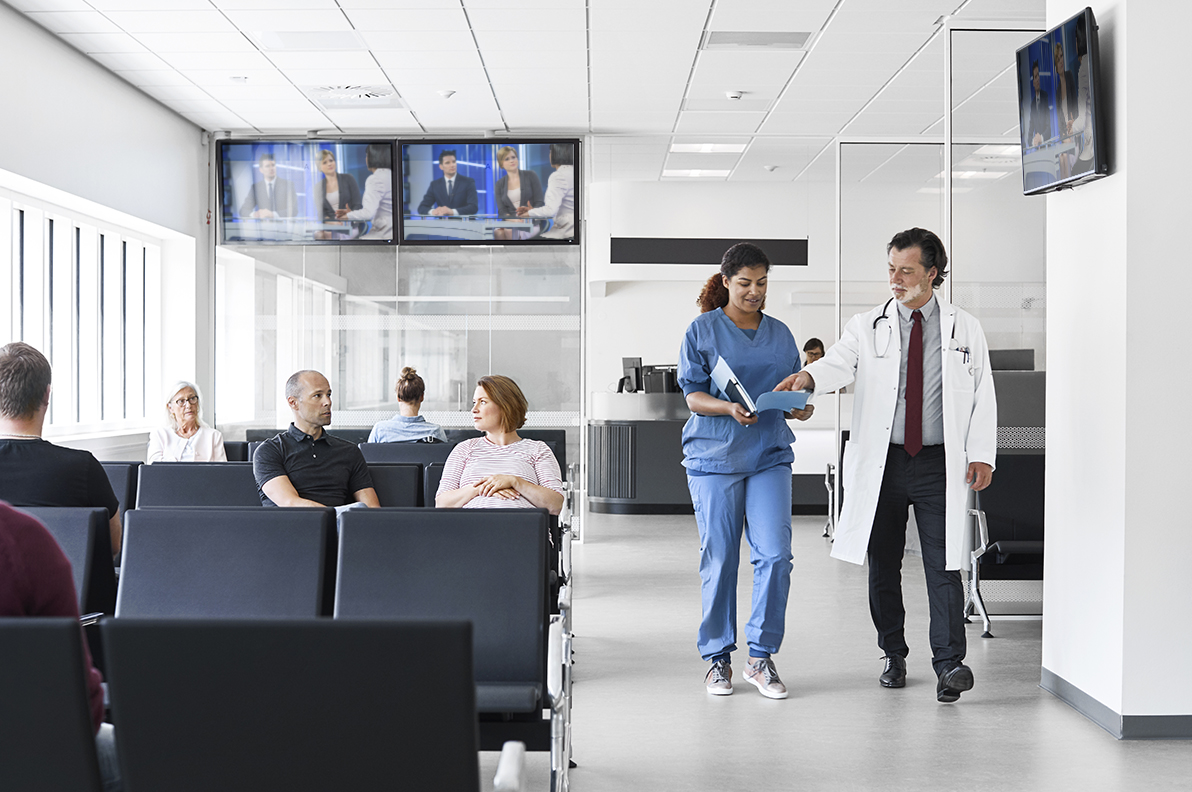 A doctor and a nurse walking through the waiting room